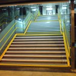 yellow handrails on station stairs